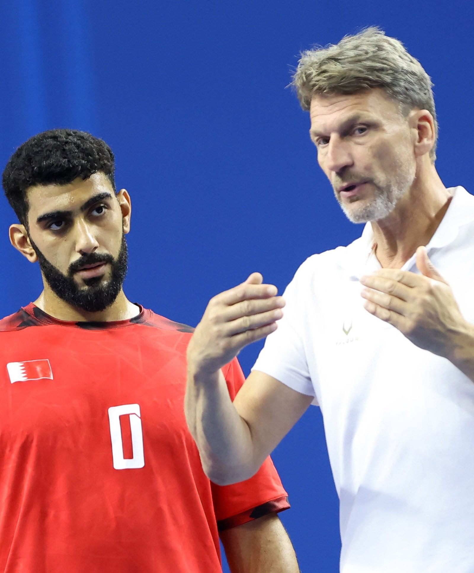 روبرت هيدين مع لاعب المنتخب البحريني